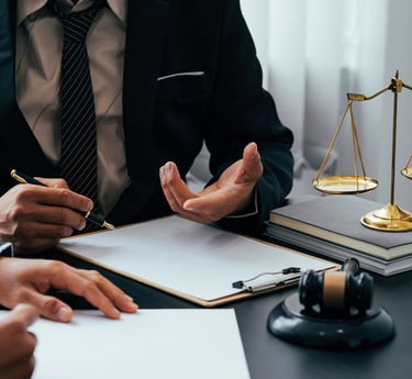 Professional lawyer in a suit providing legal advice with scales of justice and a gavel on the desk.