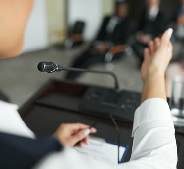 Close-up of a woman giving a speech from a lectern in a formal business atmosphere