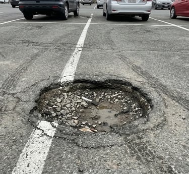pothole in a parking lot needing repair