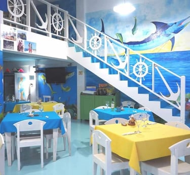 Sala ristorante dell'Hotel Big Game Maio con decorazioni marinare e murales.