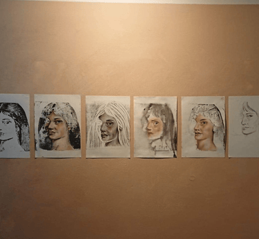 6 print and mixed media portraits of a lady on a painted rectangle section on wall.