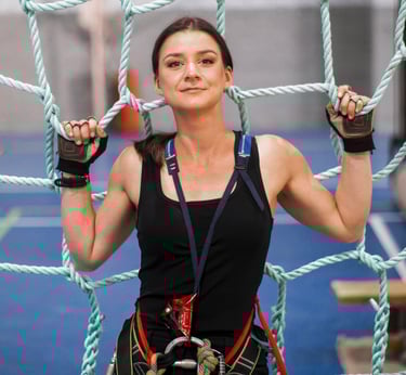 a woman in a black top and climbing harness