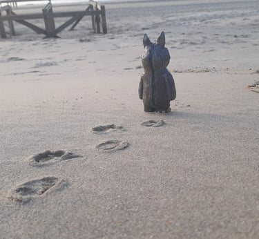 ceramic figurine walking on the sand of a beach