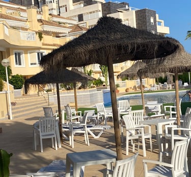 zona piscina en residencial Villas Romanas con hamacas y sombrillas