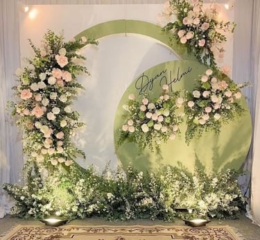 a wedding ceremony with a large green circle with flowers
