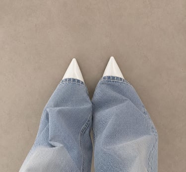 White kitten heels styled with light denim jeans.