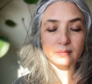 Woman with mostly white & gray hair, eyes closed