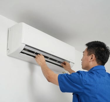 A cleaning cart is positioned in an outdoor area with a concrete building structure in the background. The cart holds a large bucket and cleaning supplies, including a striped cloth and a pink cloth hanging over the handle. A green scrubbing brush is placed on the bottom platform. Surrounding the area are vibrant flower beds with yellow and white flowers, as well as bushes and trees, contributing to a tidy and well-maintained environment.