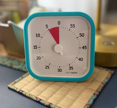 small visual timer set to 5 minutes sitting on a desk