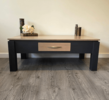 An upcycled coffee table painted with a stained wood top and drawer