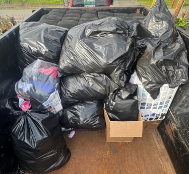 pile of trash bags and a futon in a trailer