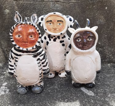three ceramic animal statues of zebr, dalmation and mountain goat smittie