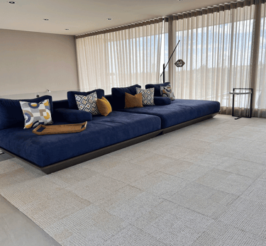 Sala minimalista con sofá azul y cojines decorativos, interiorismo | KARÄNA