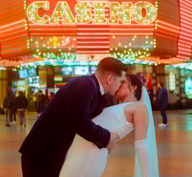 a bride and groom kissing in front of a casino