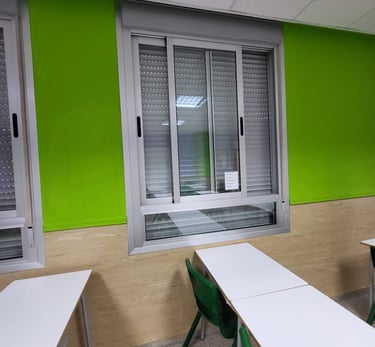Sustitución de ventanas de aluminio Climalit con persianas en centro educativo de Valencia.