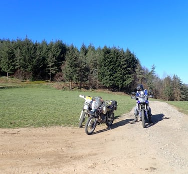 two motorcycles parked on a dirt road