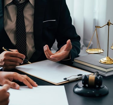 Professional lawyer in a suit providing legal advice with scales of justice and a gavel on the desk.