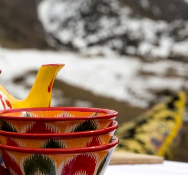 red and yellow ceramic teapot on red textile by Daniel Fox