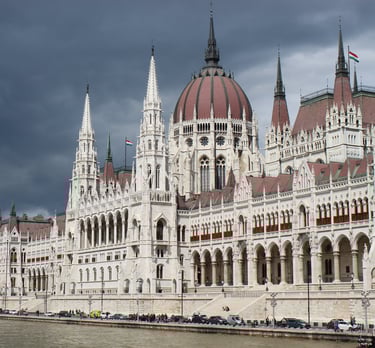 veduta del parlamento di budapest con sfondo di cielo plumbeo. contrasto netto di colori
