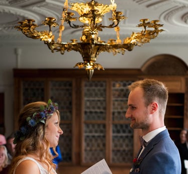 a man and woman holding hands and exchanging a wedding ring