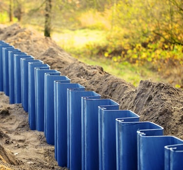 Vinyl sheet piles installed along a waterway for erosion control.