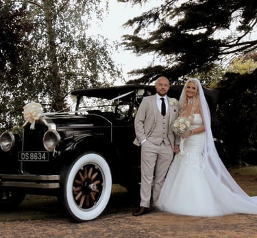 Wedding couple standin by posh car