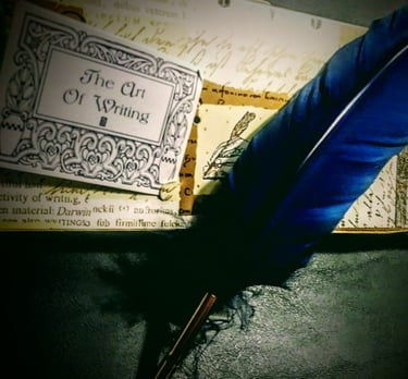 A blue feathered quill laying on a dark background - The Art of Writing