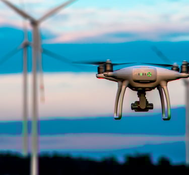 a small drone flying over a wind turbine