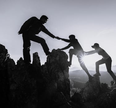 a group of people helping each other to climb up to the top of a mountain