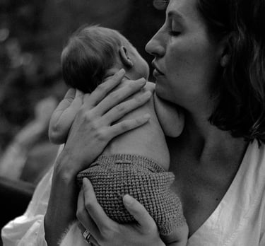 natural newborn photograph of mom holding baby looking over her shoulder