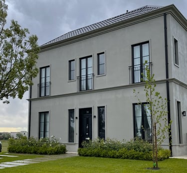 Una casa grande con un amplio césped y un árbol.