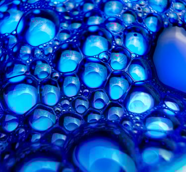a blue bowl of DarkBlue liquid with bubbles of water in it