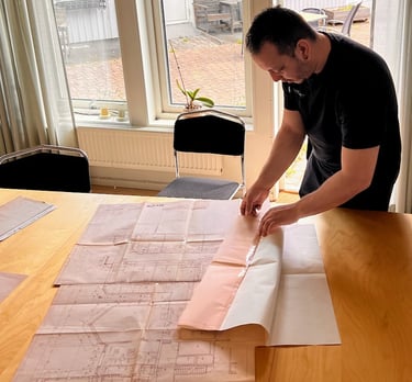 Ventilationsteknikern läser ritningar, och förbereder sig inför injustering.
