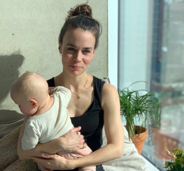 a Doula sitting, holding a baby