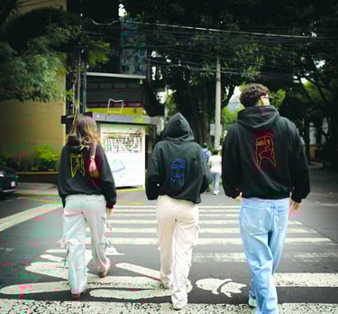 three people walking across a crosswalk in a city