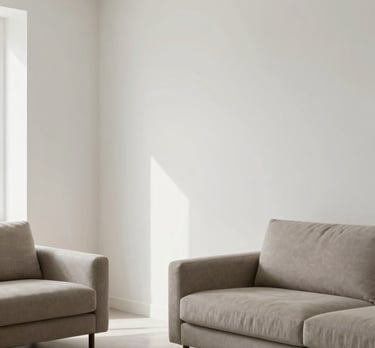 A high-end photography shot of a minimalist South Asian / Indian living room featuring flawlessly smooth white walls treated with VIHARSH putty, soft natural lighting in Soft Off-white and Taupe Grey tones.