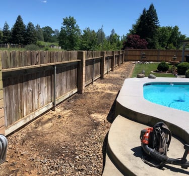 a cleared area near backyard fence and pool