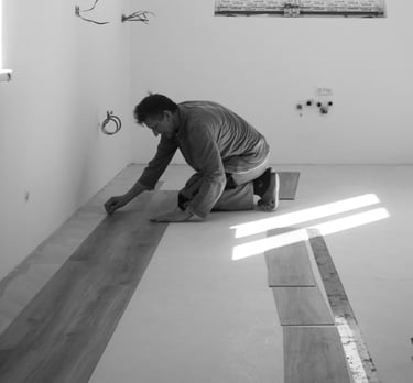 Mann in schwarzem T-Shirt und Hose, der auf dem Boden sitzt