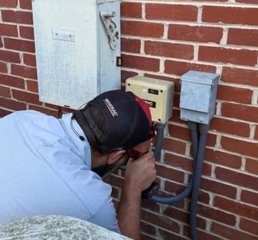 A Williams Generac Tech working on a Generac power box attached to a house