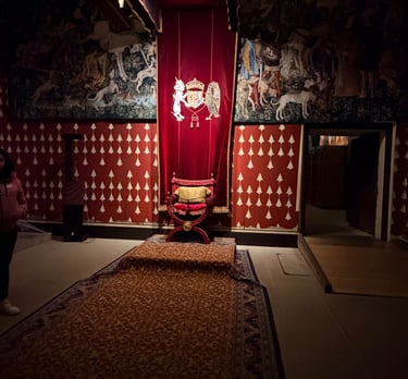 a red chair against a red tapestry and walls