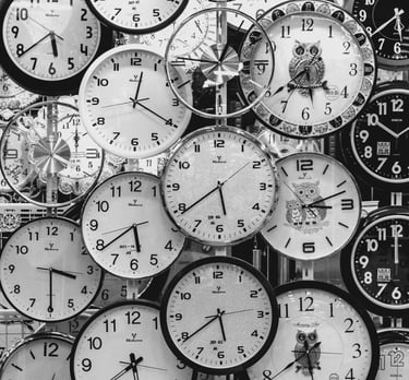 a bunch of clocks on a wall with many different clocks