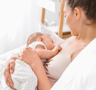 IBCLC žindymo konsultantė Eglė Gurčinė rodo kūdikio žindymo padėtį mamai per konsultaciją namuose.
