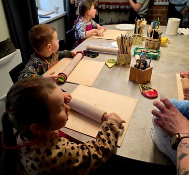 Young children using rolling pins during a creative pottery workshop and ceramics class for kids.
