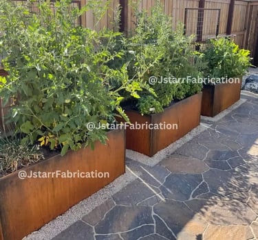 corton steel garden planter box with green plants inside