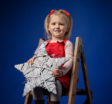 a little girl sitting on a chair with a star on it