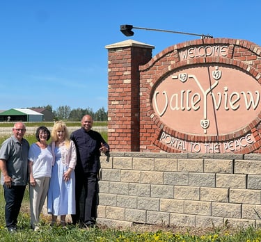 Pastors Brian and Alexis accompanied by Pastors Paul and Jan Juss at the entrance sign of Valleyview