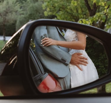 Hochzeitsfotograf Coburg: Kreative Spiegelung des Brautpaars im Außenspiegel eines Audi.