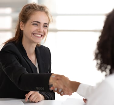 a woman in a business suit shaking hands with a man in a suit