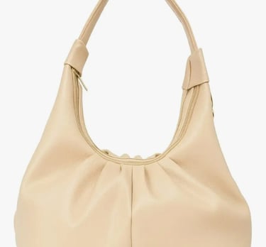 A large beige purse with a large purse on it
