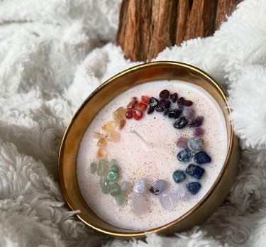 Bougie artisanale en cire végétale décorée de pierres naturelles représentant les 7 chakras, posée